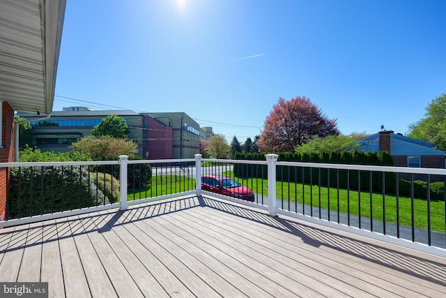 wooden deck featuring a lawn