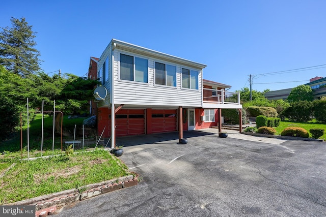 view of front of house with a garage, driveway, and a balcony