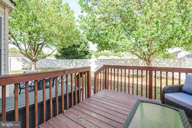 wooden deck with a fenced backyard