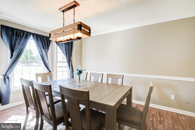 dining room featuring baseboards, ornamental molding, and wood finished floors