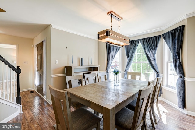 dining area with baseboards, stairs, and wood finished floors