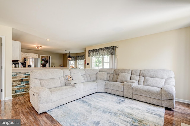 living room featuring baseboards, recessed lighting, and wood finished floors