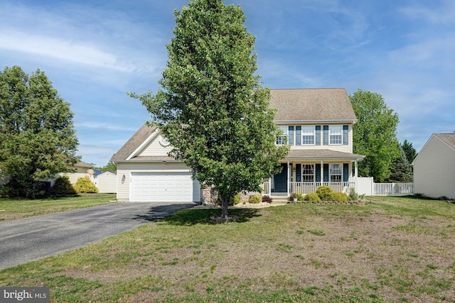 colonial-style house with a porch, an attached garage, driveway, and a front lawn