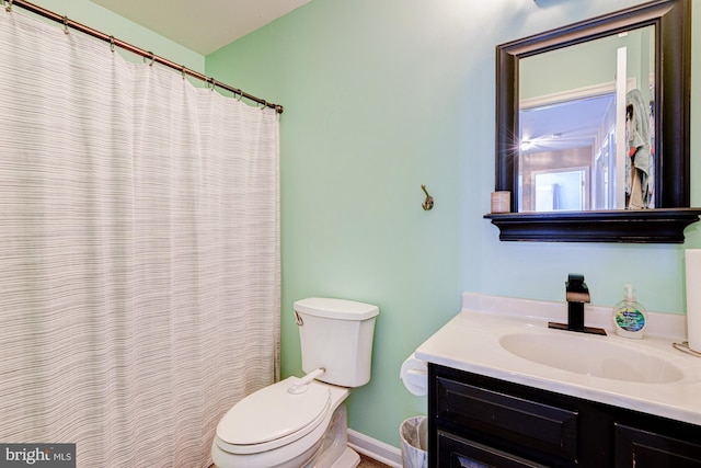 full bathroom with toilet, baseboards, and vanity