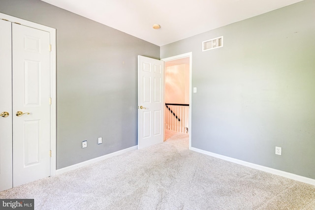 unfurnished bedroom featuring visible vents, carpet, and baseboards