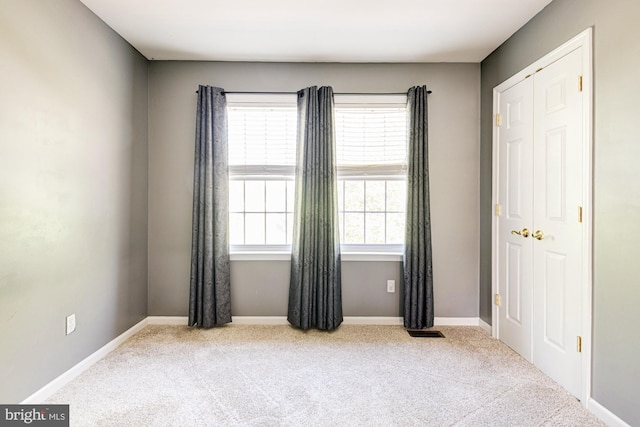 unfurnished room featuring baseboards and carpet