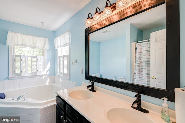 full bath featuring a sink, a garden tub, double vanity, and visible vents