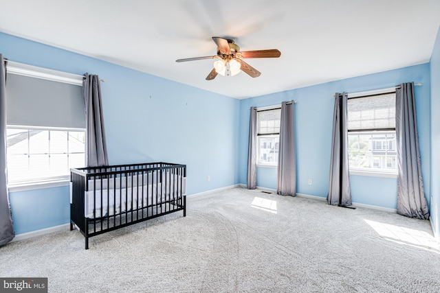 unfurnished bedroom with baseboards, a ceiling fan, and carpet