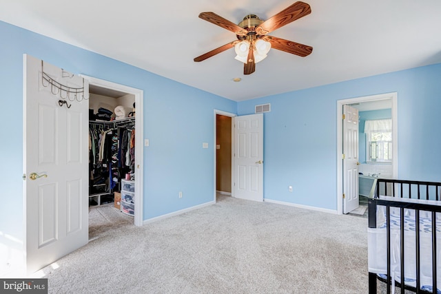 unfurnished bedroom featuring visible vents, carpet, baseboards, and a spacious closet