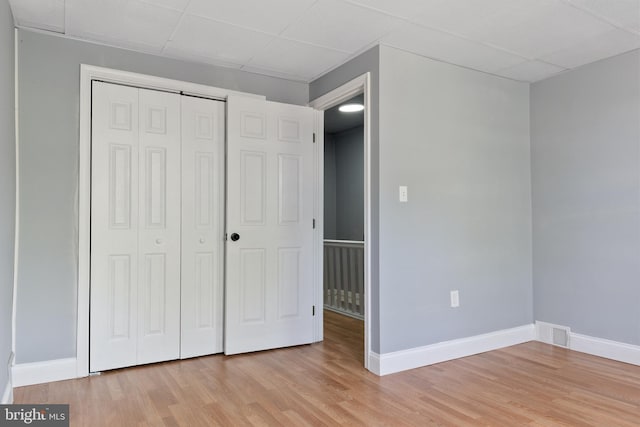 4018 Pennington Ave, Baltimore City, MD 21226 - unfurnished bedroom with baseboards, a paneled ceiling, light wood finished floors, and a closet