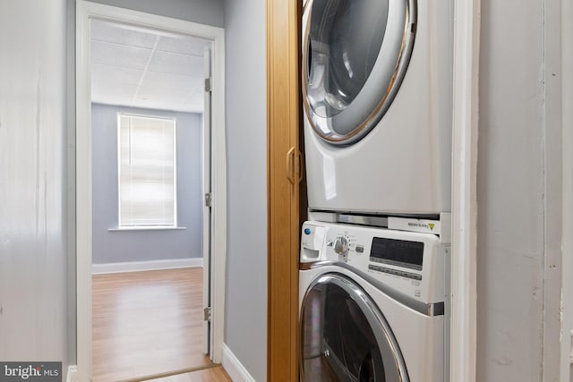 4018 Pennington Ave, Baltimore City, MD 21226 - clothes washing area featuring stacked washing maching and dryer, baseboards, laundry area, and light wood-style flooring
