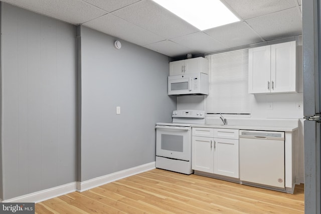 4018 Pennington Ave, Baltimore City, MD 21226 - kitchen with white appliances, light countertops, white cabinetry, and light wood-style floors