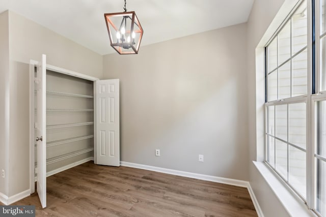 interior space featuring wood finished floors, a chandelier, and multiple windows
