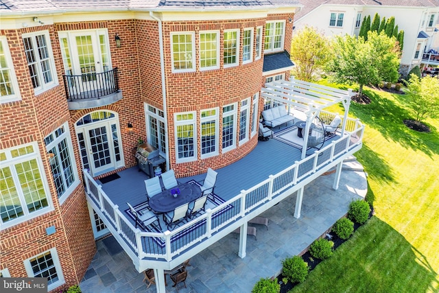 rear view of property featuring brick siding, outdoor dining area, a yard, and a pergola