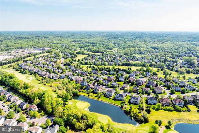 drone / aerial view featuring a water view, view of golf course, and a residential view