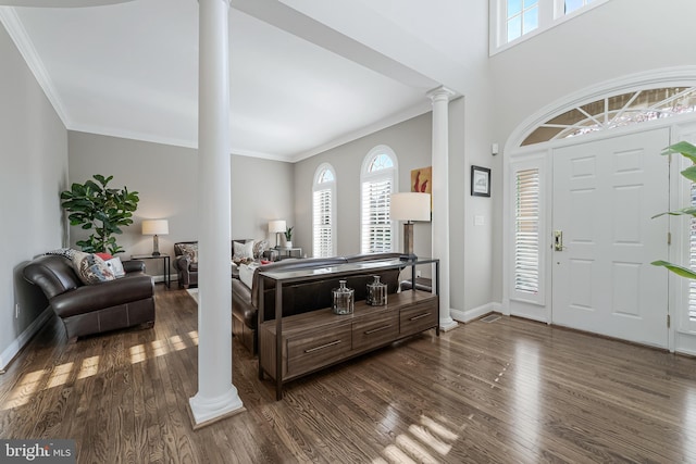 entryway with ornamental molding, decorative columns, dark wood-style floors, and a wealth of natural light
