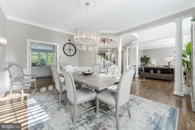 dining area with ornate columns, ornamental molding, wood finished floors, and stairway