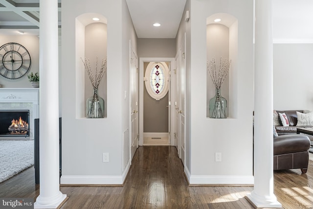 hallway with baseboards, decorative columns, and wood finished floors