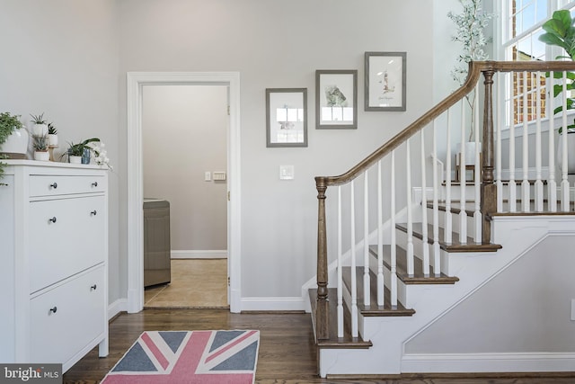 foyer with baseboards, dark wood-style flooring, and stairs