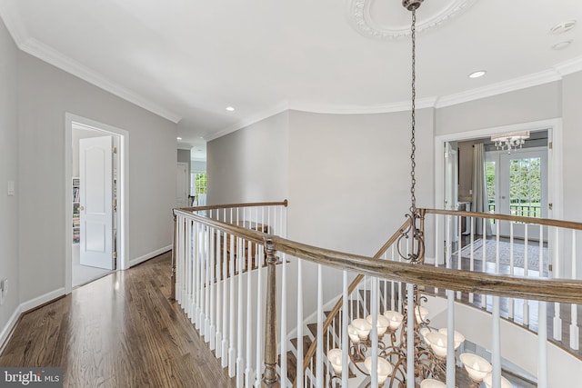 corridor featuring ornamental molding, recessed lighting, wood finished floors, and an upstairs landing
