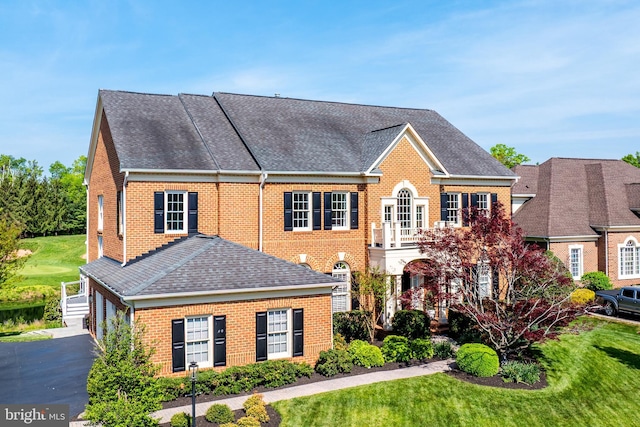 view of front facade featuring brick siding, a shingled roof, and a garage