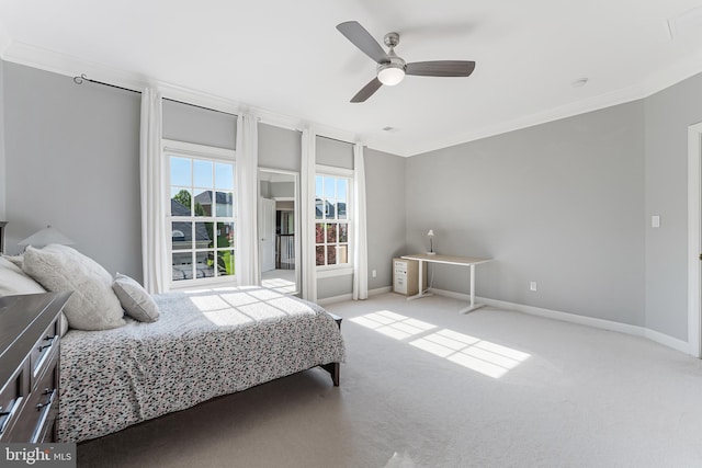 carpeted bedroom featuring baseboards, ornamental molding, and ceiling fan