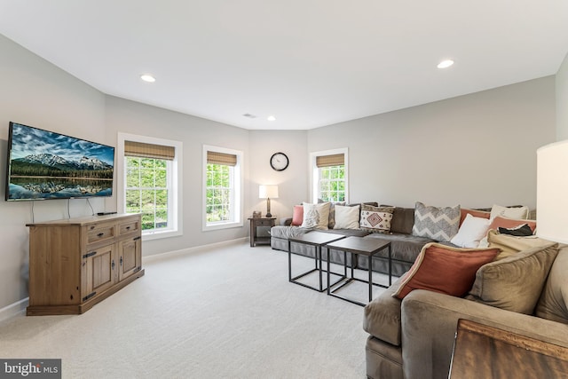 living area with baseboards, recessed lighting, and light carpet