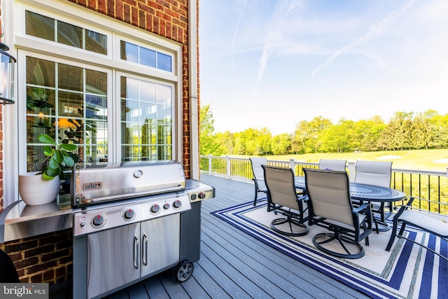 deck featuring outdoor dining area and a grill