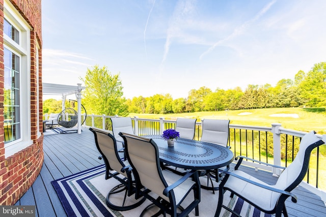 wooden deck with outdoor dining space and golf course view