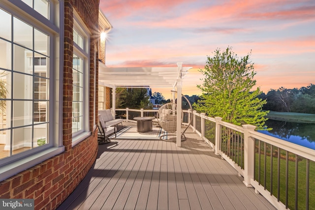 deck at dusk featuring a water view