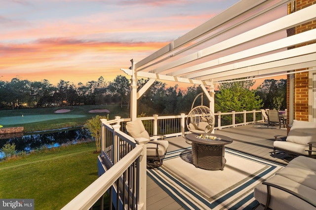 deck at dusk featuring a lawn, an outdoor living space with a fire pit, and a pergola