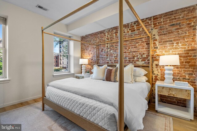 1224 11th St NW Unit 3, Washington, DC 20001 - bedroom featuring visible vents, wood finished floors, and brick wall
