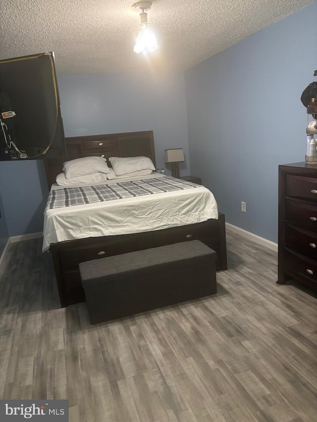 1852 Village Green Dr Unit E-122, Landover, MD 20785 - bedroom featuring baseboards, a textured ceiling, and wood finished floors