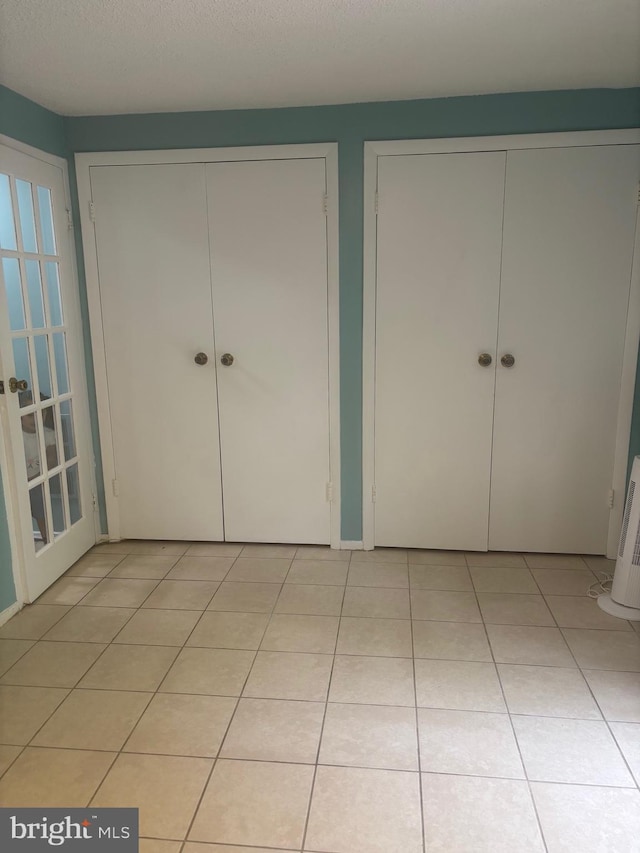 1852 Village Green Dr Unit E-122, Landover, MD 20785 - unfurnished bedroom with light tile patterned floors and multiple closets