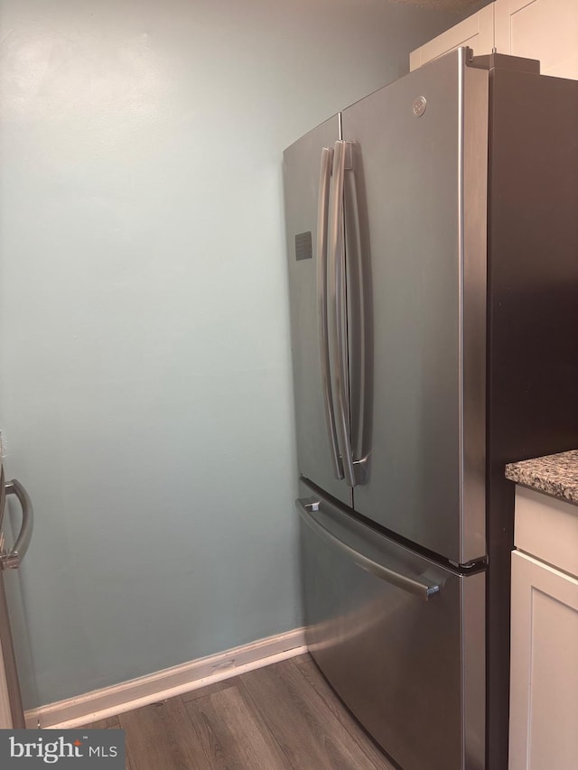 1852 Village Green Dr Unit E-122, Landover, MD 20785 - interior details with freestanding refrigerator, baseboards, light stone counters, and wood finished floors