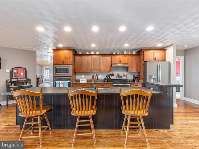 1996 Buck Mountain Rd, Bentonville, VA 22610 - kitchen featuring a sink, stainless steel appliances, brown cabinetry, baseboards, and light wood-type flooring