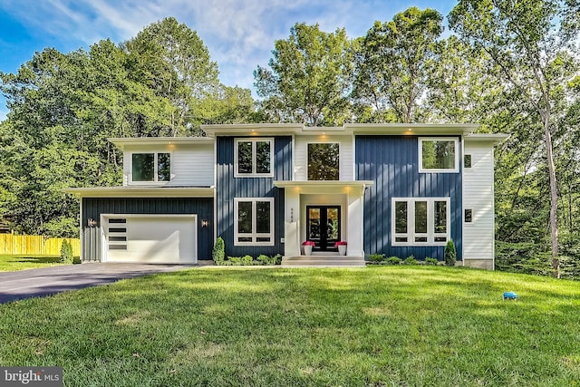 view of front of property featuring board and batten siding, french doors, a front yard, a garage, and aphalt driveway