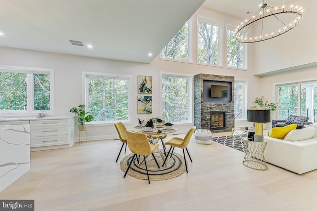 dining space with recessed lighting, a stone fireplace, visible vents, and plenty of natural light