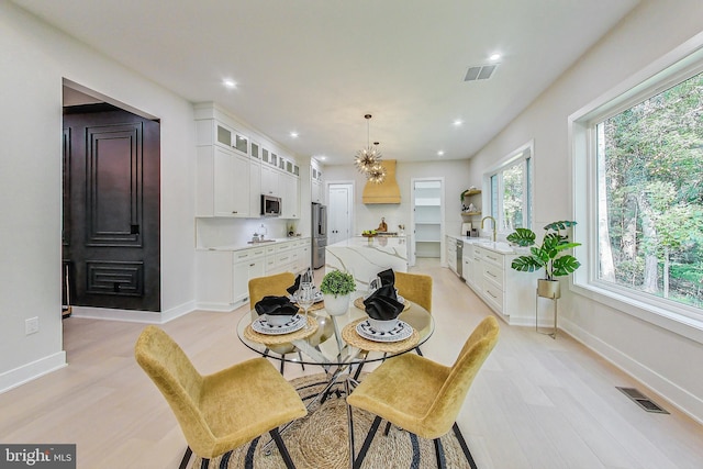 dining room with visible vents, baseboards, and light wood-type flooring