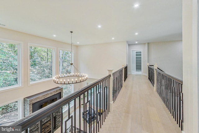 hall with recessed lighting, a notable chandelier, an upstairs landing, and light wood-type flooring