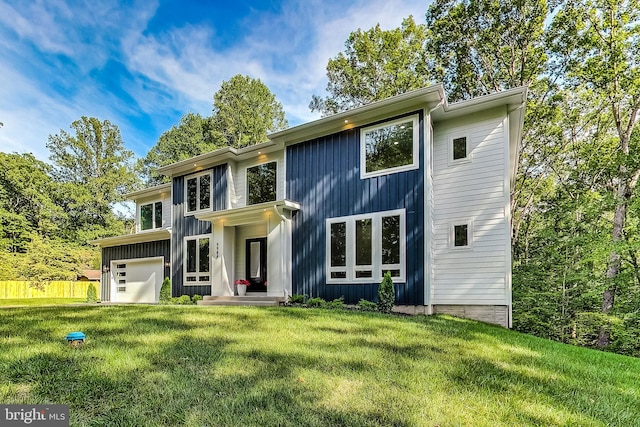view of front of house with board and batten siding, a front yard, and a garage