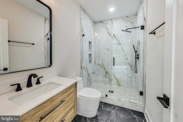 bathroom featuring toilet, a marble finish shower, marble finish floor, and vanity