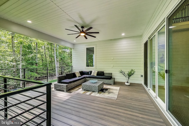 wooden terrace with an outdoor living space and a ceiling fan
