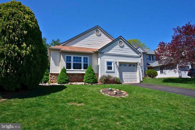 view of front of house with stone siding, an attached garage, a front lawn, and aphalt driveway