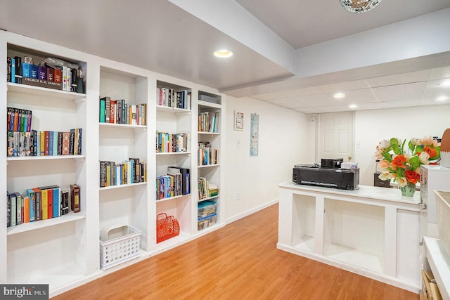 office featuring built in shelves, recessed lighting, and wood finished floors