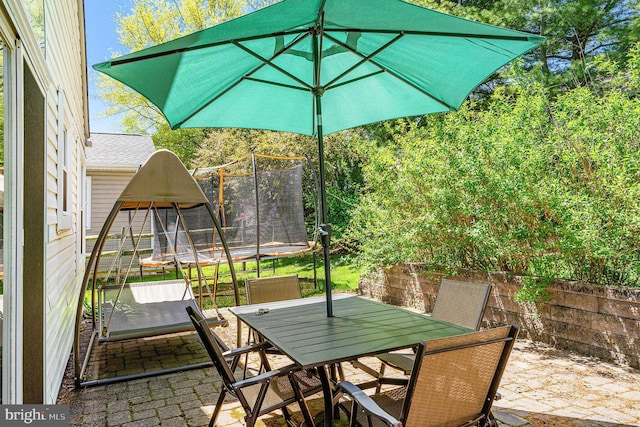 view of patio / terrace featuring a trampoline and outdoor dining space