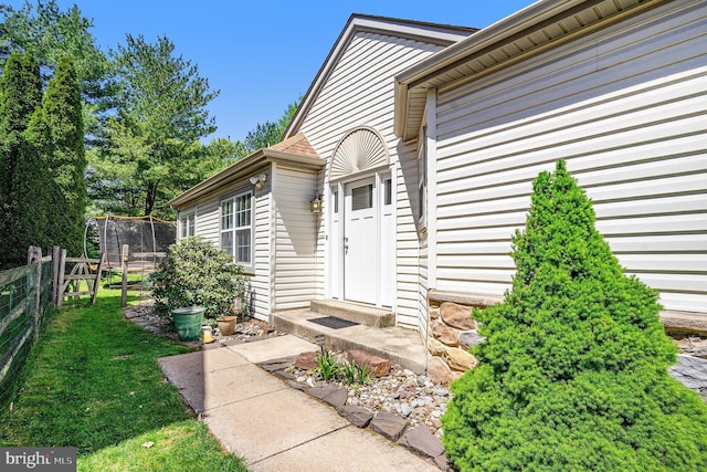 property entrance with a lawn and fence