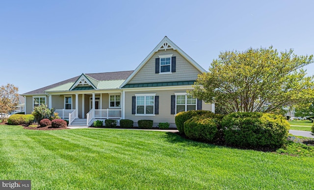 view of front of house featuring metal roof, a front lawn, covered porch, and a standing seam roof