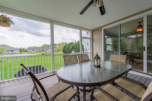 sunroom / solarium with outdoor dining area, a ceiling fan, and a residential view
