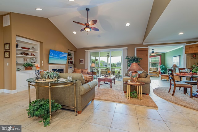 living area featuring lofted ceiling, light tile patterned flooring, a ceiling fan, and built in features